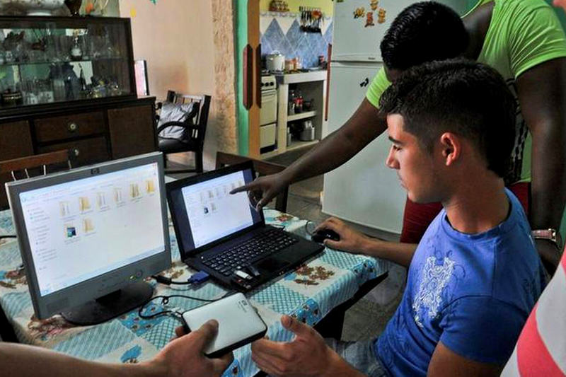 Jóvenes preparan discos portátiles y unidades USB con películas, series de televisión, noticias y otra información, en abril del 2014 en La Habana. Solo el 3.4% de la población tiene conexiones privadas de internet. STR AFP/Getty Images