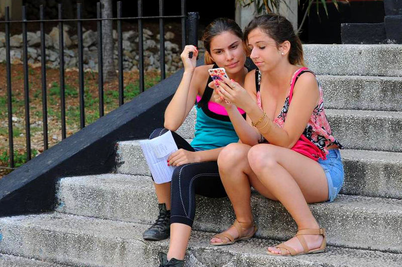 Cubanos usan dispositivos móviles para conectarse vía Wi-Fi en La Habana. Etecsa, la empresa de telecomunicaciones del estado, abrió 35 áreas Wi-Fi en el país y redujo las tarifas de conexión a la mitad del precio en un esfuerzo por ampliar la limitada conectividad de la isla. YAMIL LAGE AFP/Getty Images