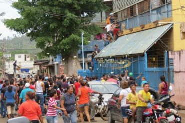 ¡MÍRALOS! Así lanzan billetes de Bs. 50 de un abasto chino durante saqueos en El Callao (+Video)