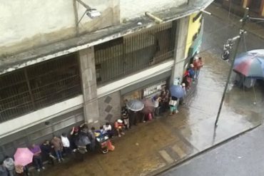 ¡SOLO EN VENEZUELA! Llueve fuerte sobre Caracas y la gente no se mueve de la cola del pan